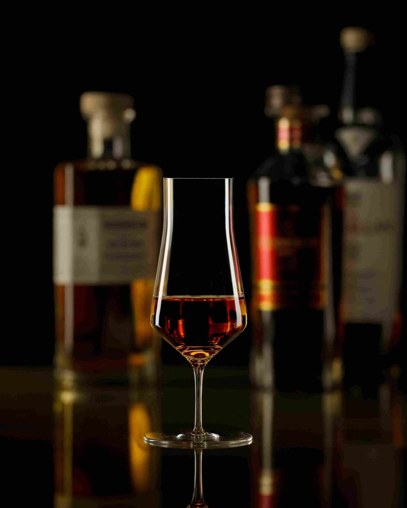 Zalto Denk'Art Cask whiskyglas met whisky en flessen op de achtergrond